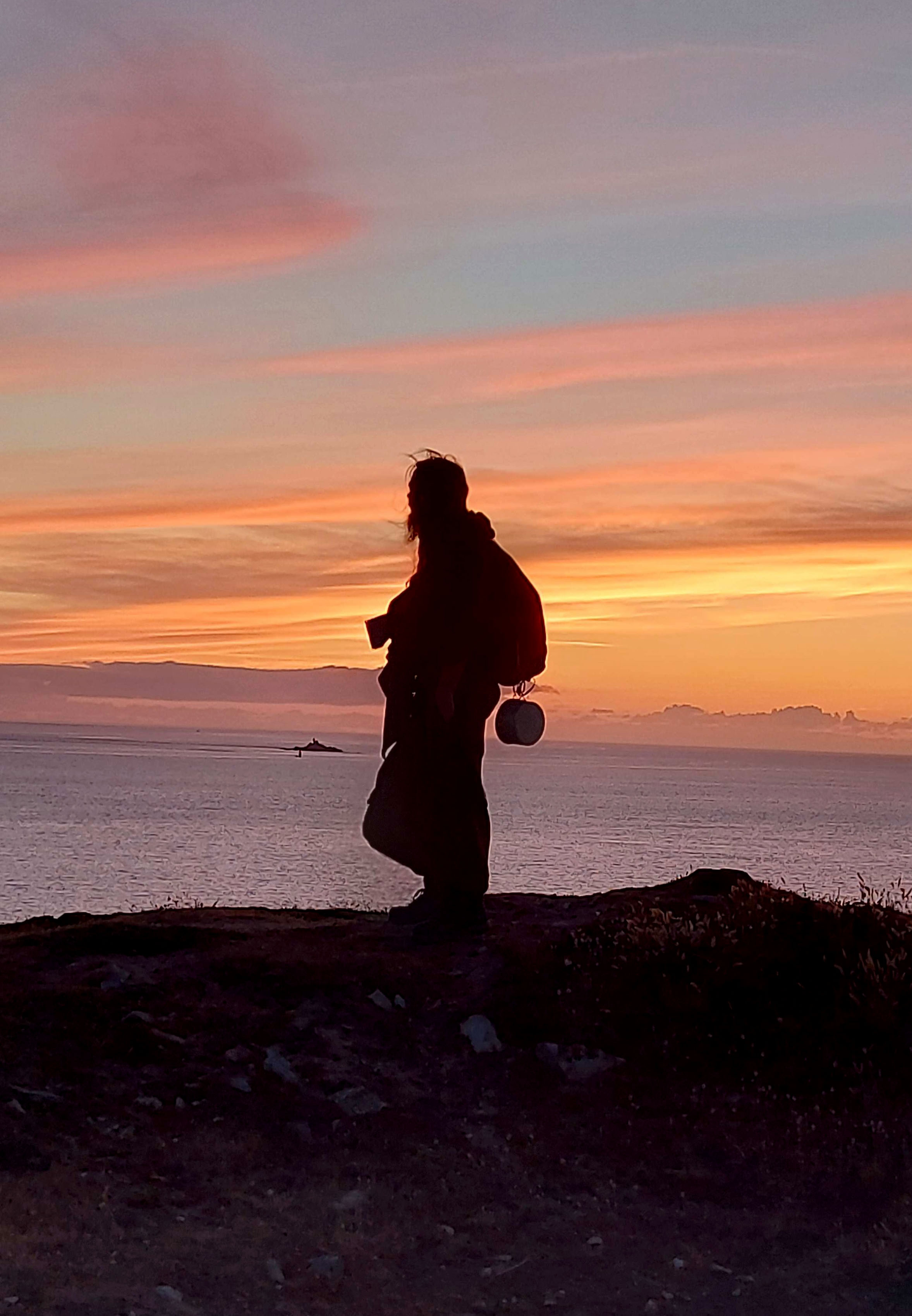 Noé perché sur une falaise regarde vers l'horizon, au-delà de l'océan. Le crépuscule fait apparaitre Noé telle une ombre, avec une casserole pendue a son sac !